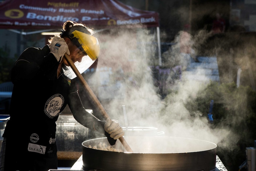 A food vendor stirs their pot at Malak markets