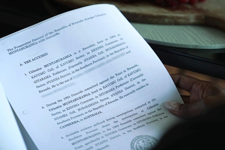 A hand holding a document which includes the words 'the accused'.