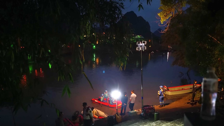 Rescue boats are seen in the river at night time.