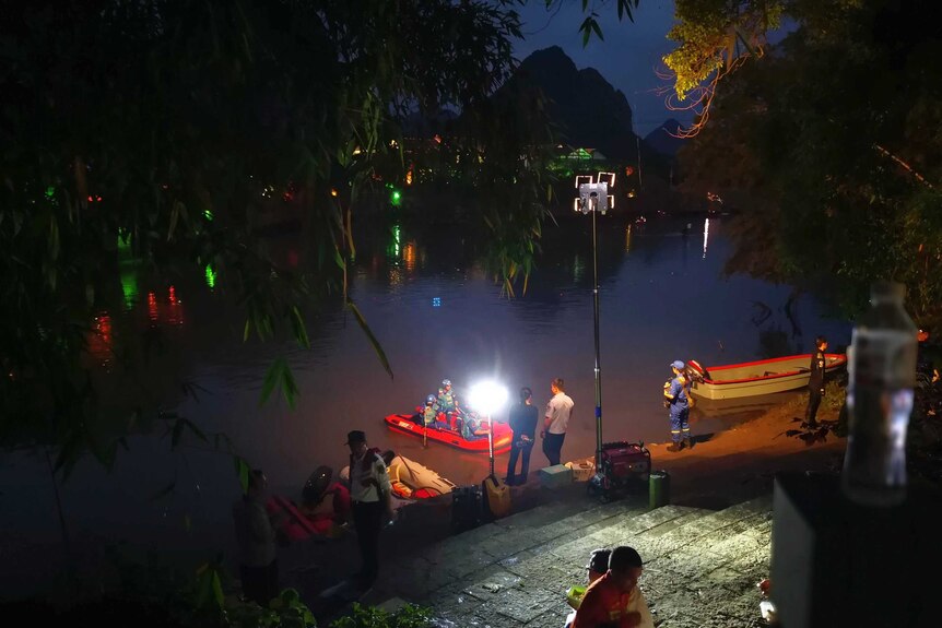 Rescue boats are seen in the river at night time.