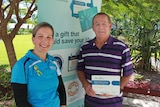 rachel and david smiling in front of a bowel cancer awareness sign at the Mackay Base Hospital