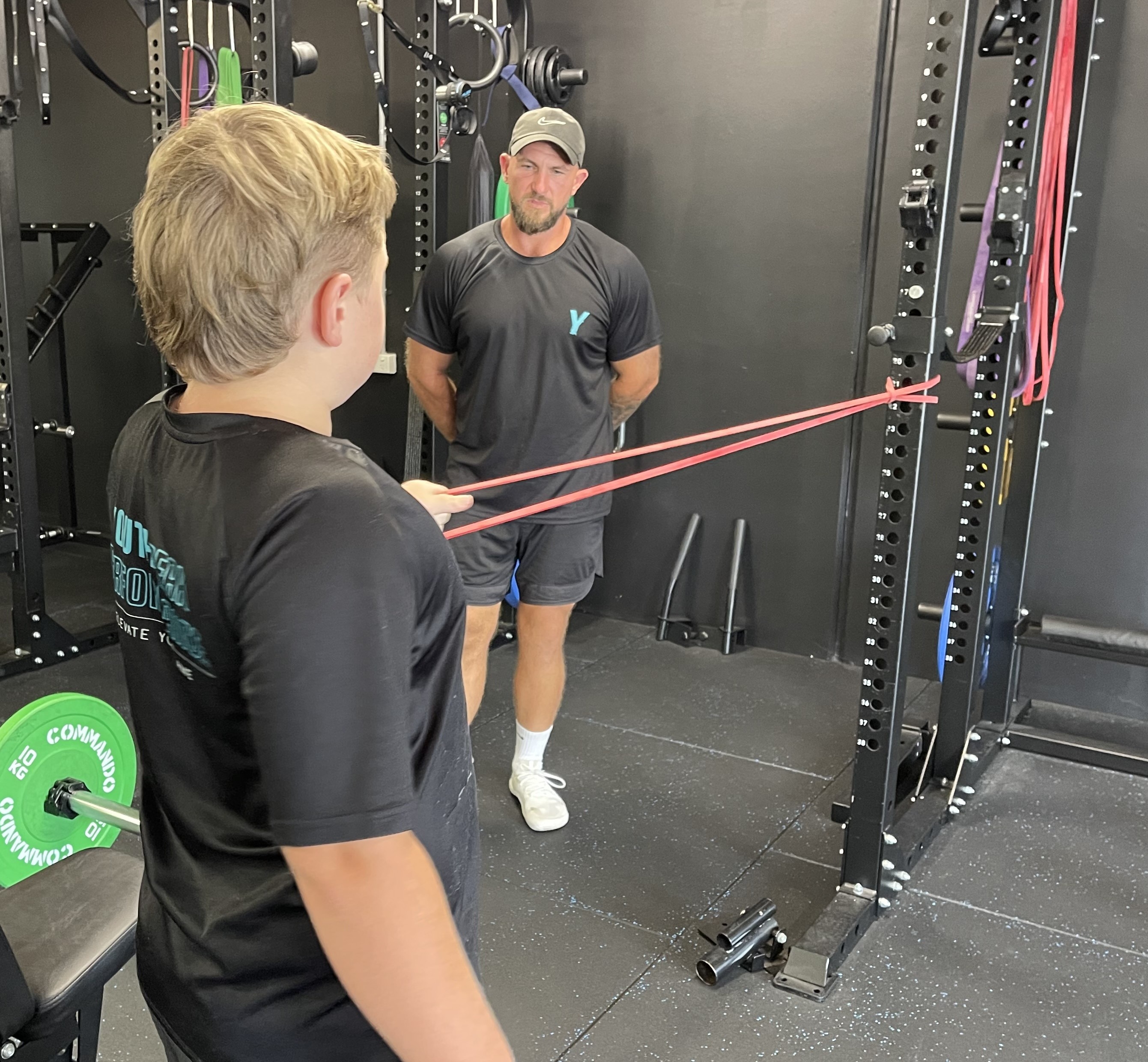 Jackson Mackay, poseedor del récord mundial de peso muerto, de nueve años, calienta con una banda, asistido por su entrenador Joshua Hodges. 