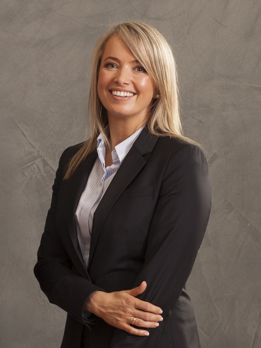 A woman with blonde hair wearing a black blazer