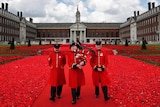 Chelsea Pensioners walk through the 5,000 Poppies Garden.