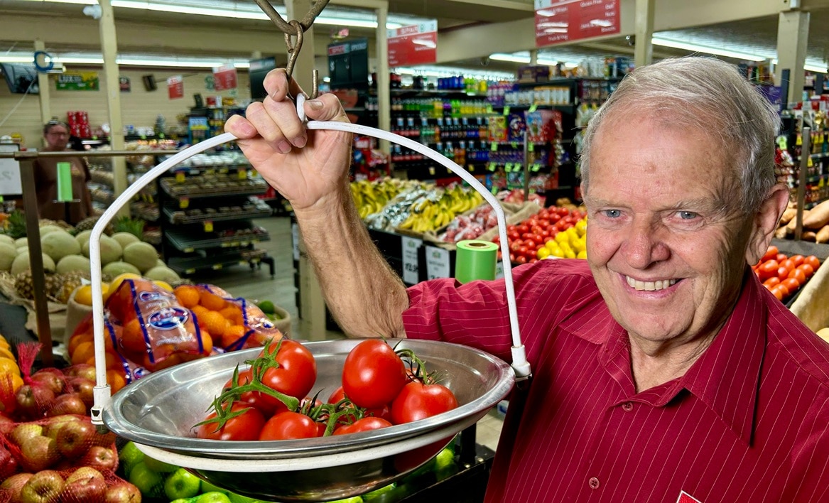homem no supermercado com tomates vermelhos na balança