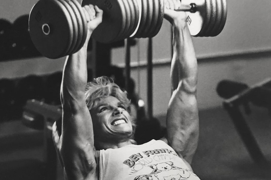 Bev lifts giant dumbells.