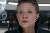 Princess Leia in Star Wars The Last Jedi looks out of a spaceship window.