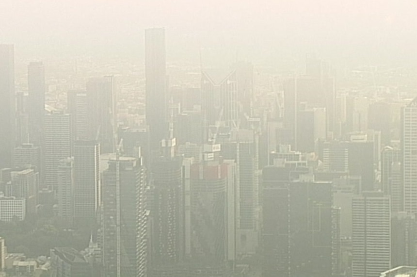 A grey haze hangs over the Melbourne CBD, viewed from a helicopter.