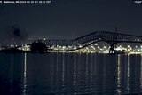 A scene late at night of a bridge mid collapsing.