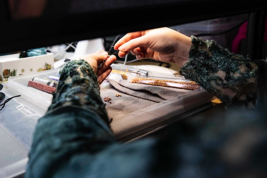 Close up of visually impaired beader Asha Martin at work.