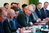 Boris sits among members of his former Cabinet making a surprised expression