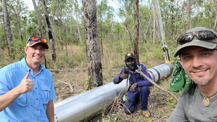 Scott Bissett (NASA), Anthony Kennedy (Mimal), Peter Elstner (NASA) in the bush with a piece of a rocket.