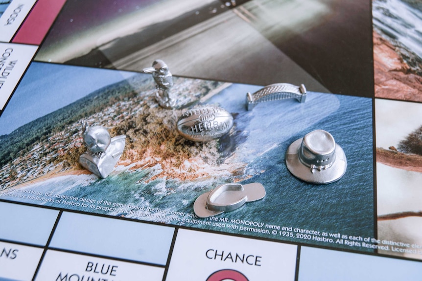 Close up of Monopoly board featuring Australian locations, with silver playing tokens including the Harbour Bridge and Kangaroo