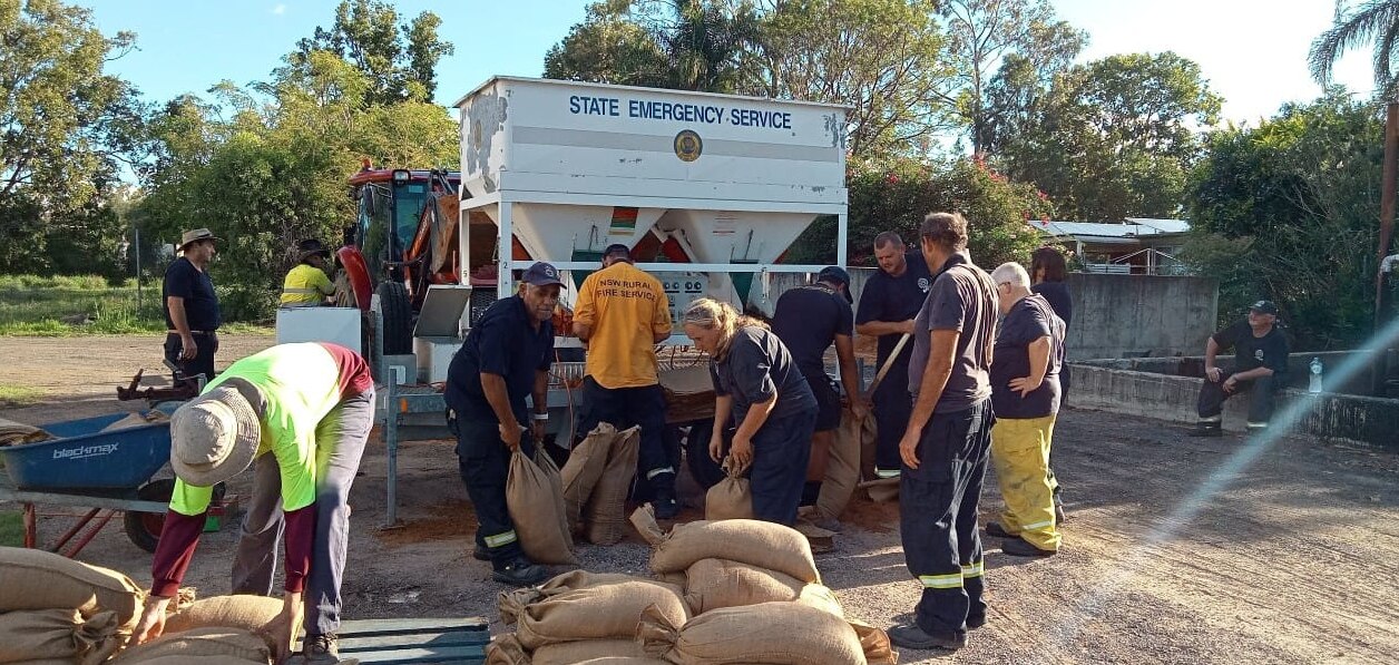 Emergency service personnel filling sandbags.