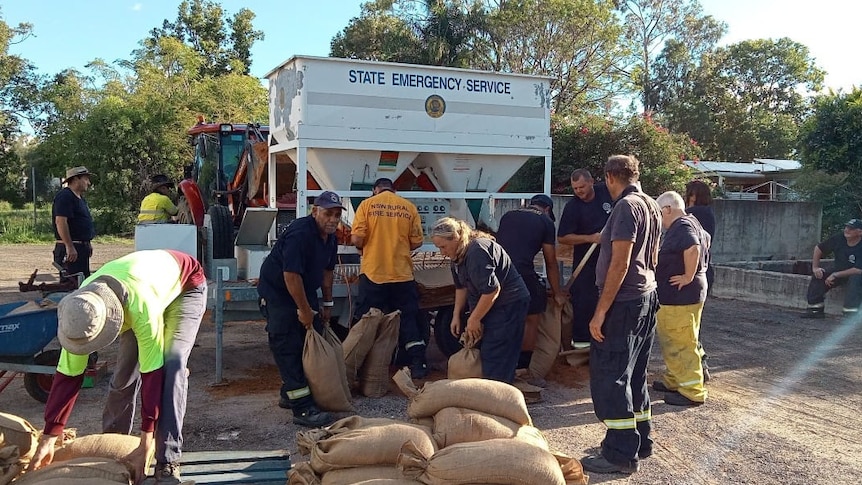 Emergency service personnel filling sandbags.