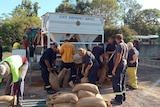 Emergency service personnel filling sandbags.