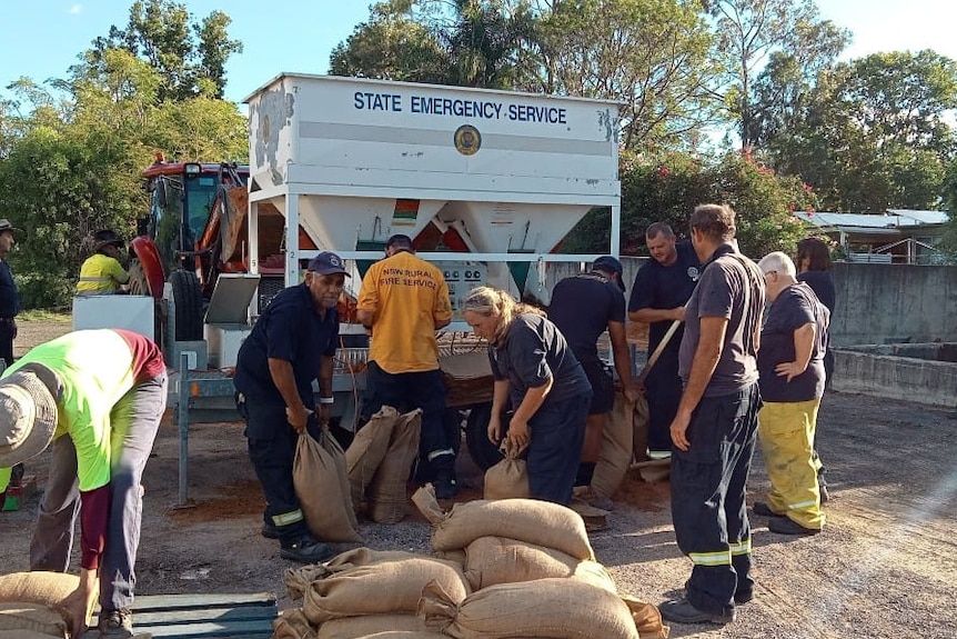 Emergency service personnel filling sandbags.