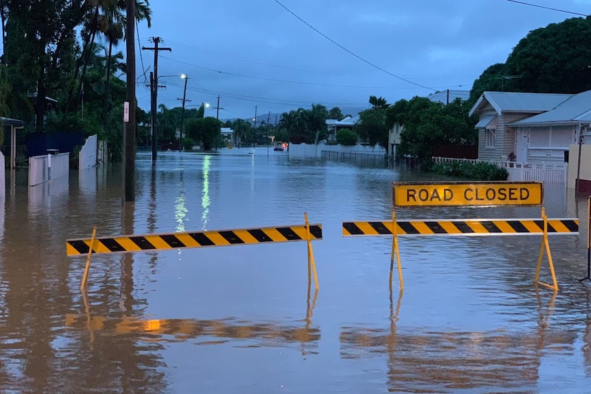 A flooded street with a 'Road Closed' sign in the Townsville suburb of Railway Estate.