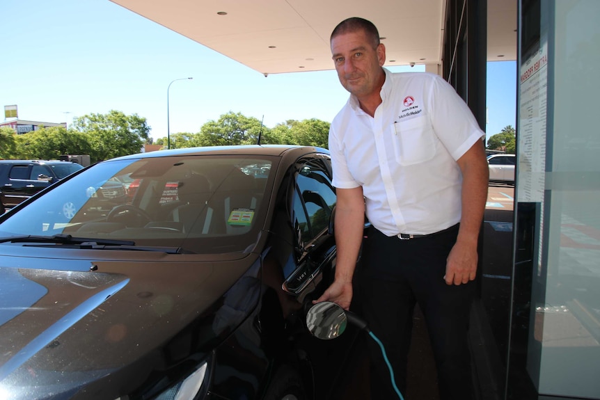 Car dealer Paul Davies charges a Holden Volt electric vehicle.