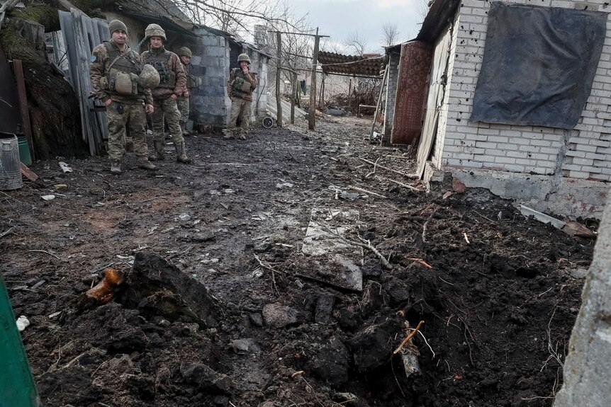 Ukrainian soldiers survey damage on the frontline after shelling in Donetsk, February 19, 2022.
