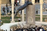 Iraqis watch the statue of Saddam Hussein fall in Baghdad's al-Fardous square on April 9, 2003.