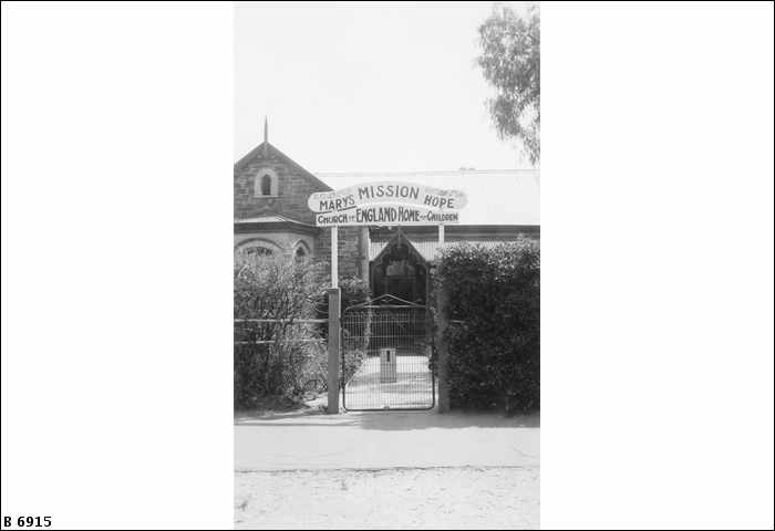 Fotografía en blanco y negro de una puerta debajo de un letrero que dice 