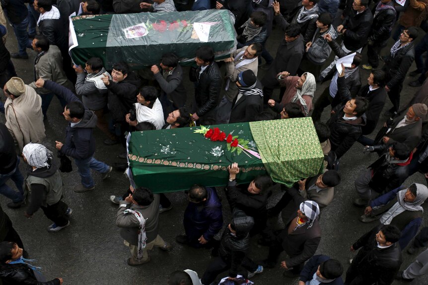 Men carry coffins of two of the seven Hazara victims who were killed by unknown Islamist militants in Afghanistan