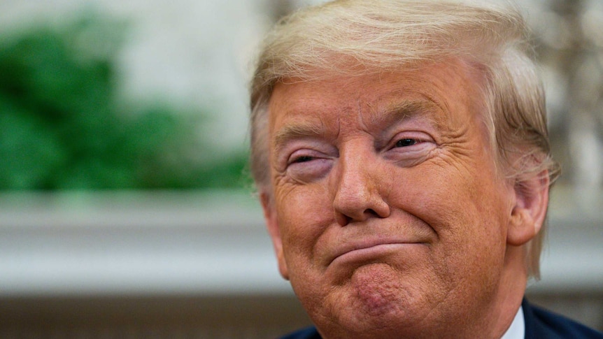 President Donald Trump smiles during a meeting