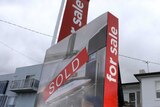 Sold sticker across a real estate sign outside a Hobart house