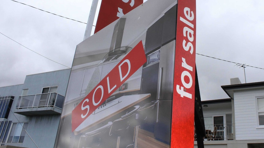Sold sticker across a real estate sign outside a Hobart house