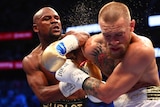 Sweat flies as Floyd Mayweather Jr lands a punch on Conor McGregor.