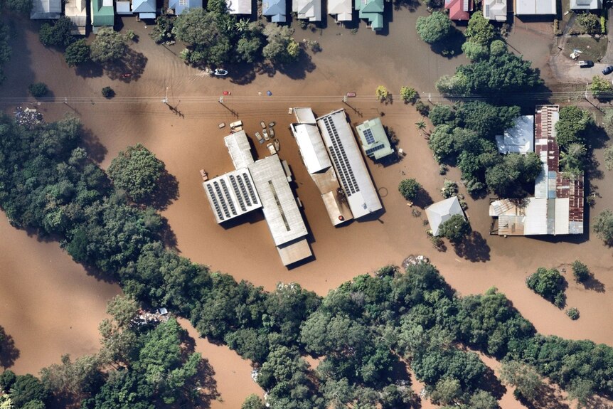 Industrial buildings are seen from above, still inundated by floodwaters.
