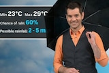 ABC weather presenter Nate Byrne holds an umbrella and stands in front of a rain forecast.