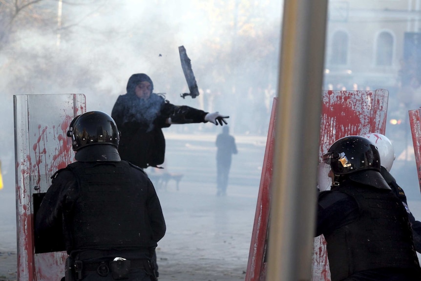 A protester clashes with police in Kosovo's capital Pristina.