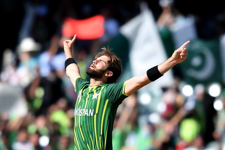 Shaheen Afridi stands with his arms outstretched and pointing up, head back and eyes closed