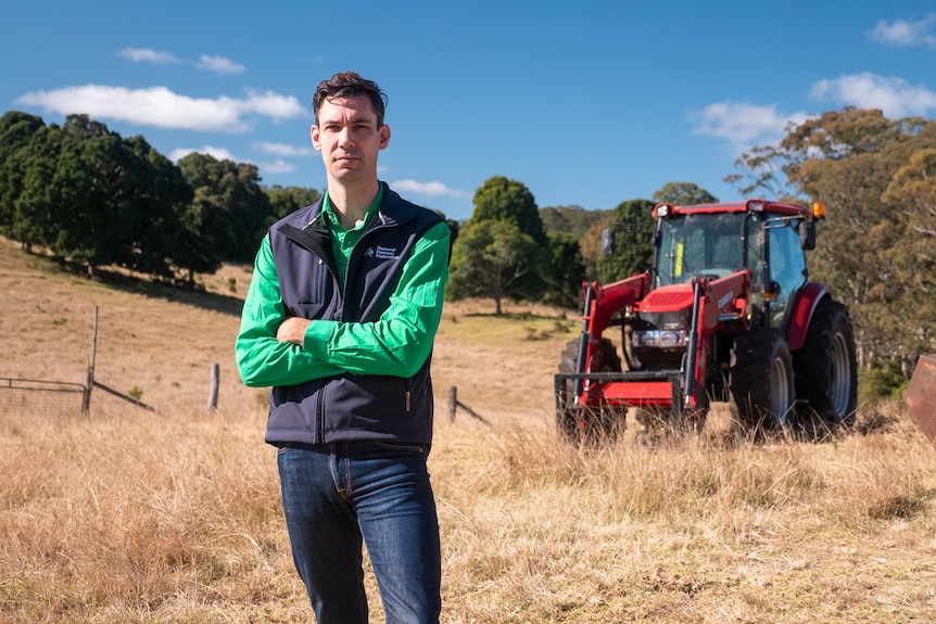 A photo of Richard Shannon standing in front of tractor on his family's farm near Toowoomba, Queensland, June 2024.