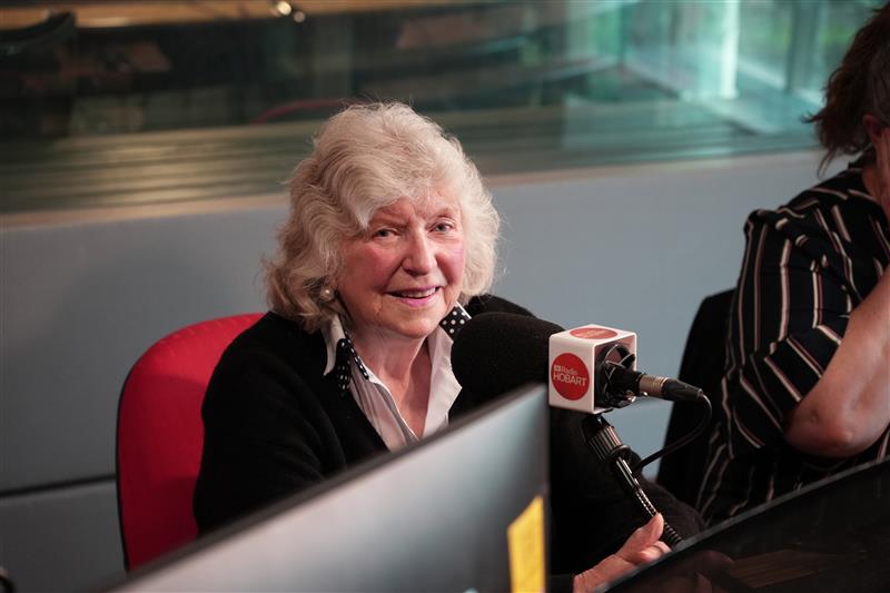 Una mujer habla por un micrófono en un estudio.