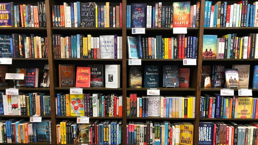 Four bookshelves of books at a bookstore