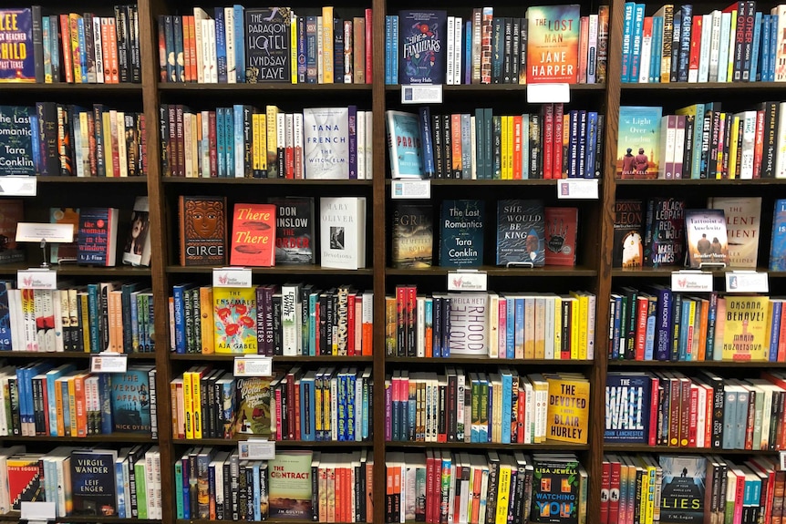 Four bookshelves of books at a bookstore