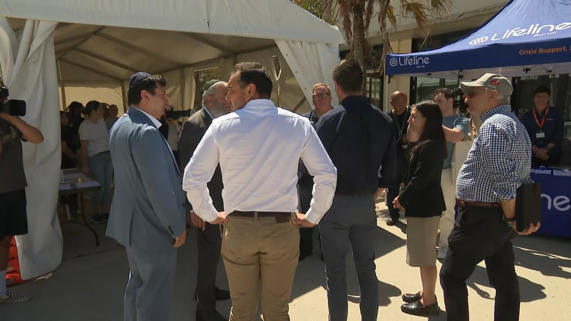 Una multitud de personas frente a un centro, con un letrero de Lifeline al fondo