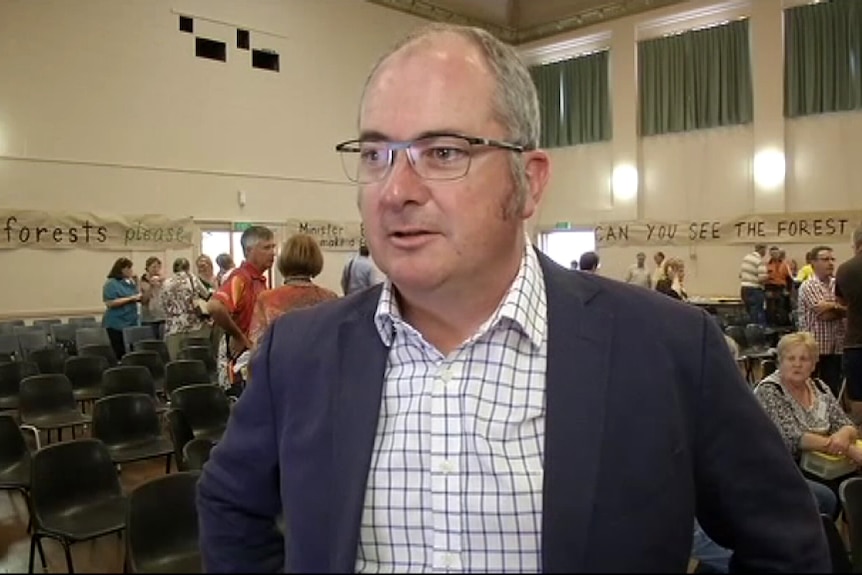 A man wearing glasses and a blazer