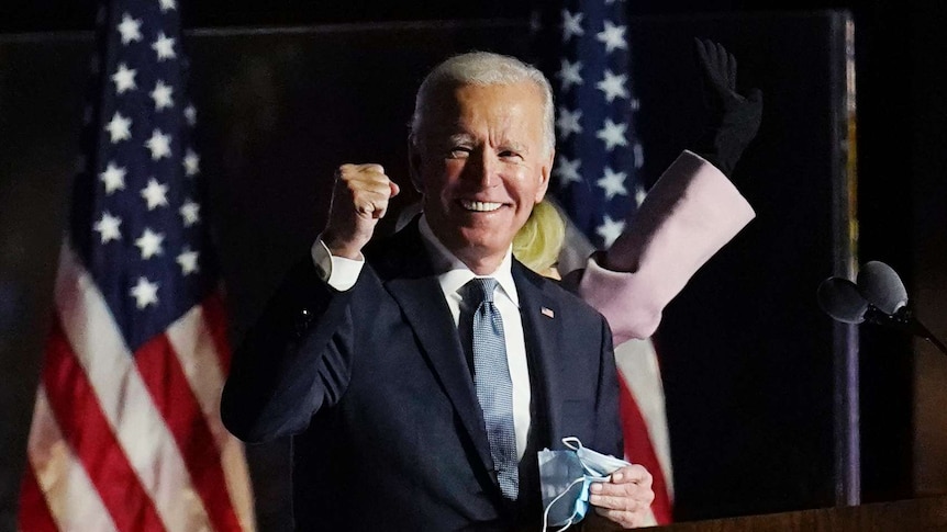 Joe Biden clenches a fist and smiles.