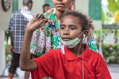 young darts player with covid mask in PNG