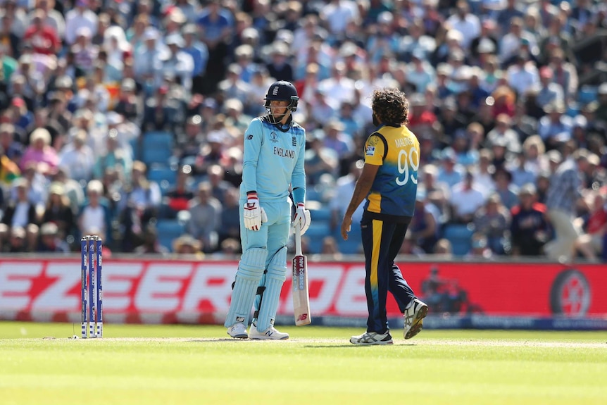 A batsman stares after being caught behind, while the bowler eyes him waiting to celebrate.