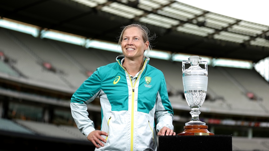 ustralian Women’s Captain Meg Lanning standing next to the Ashes Trophy