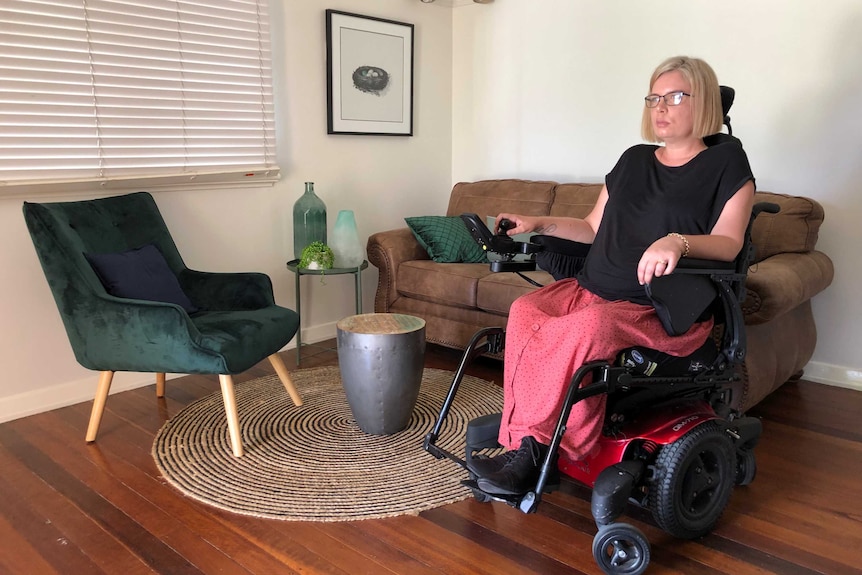 Kelly Cox in her wheelchair in her living room.