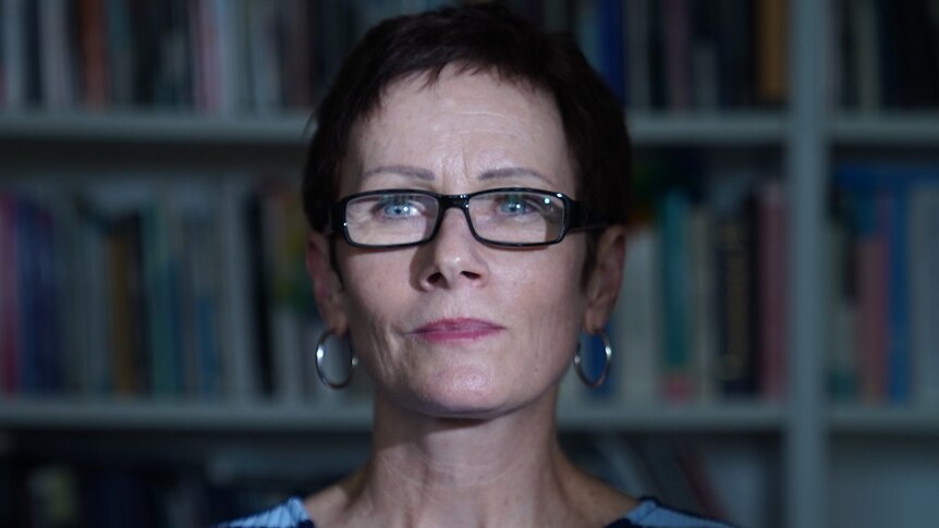 Professor Gail Mason stands in front of a bookshelf, she is a criminologist who researched the Bias Crimes Unite of NSW Police.