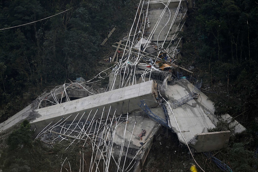 A close up shows the broken concrete pilons and connector cables