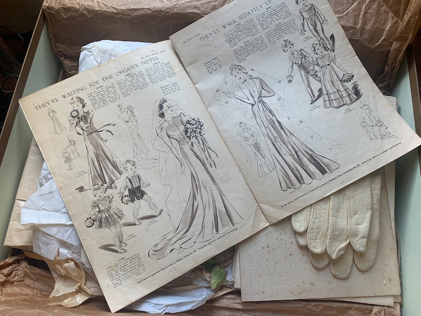 An old, yellowing magazine with sketches of brides in different dresses.