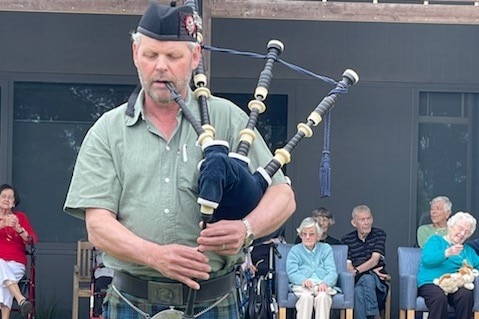 An older man playing the bagpipes